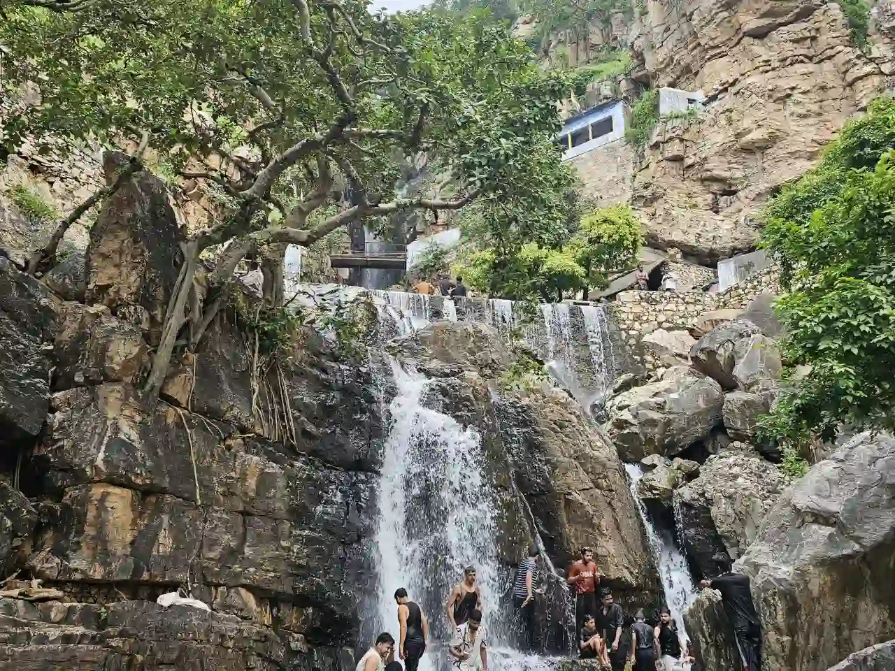 Devotees at Amreshwar Mahadev Temple Sawai Madhopur Rajasthan surrounded by rocky hills and greenery